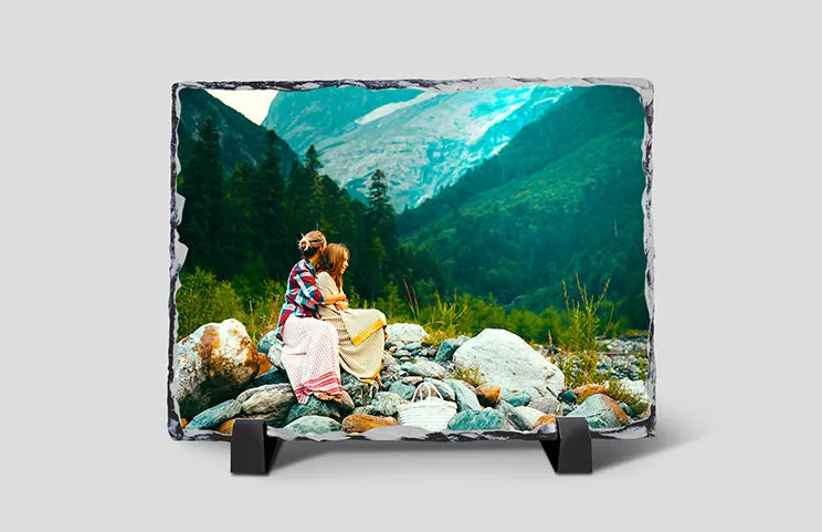 Photo souvenir personnalisée : deux femmes assises sur des rochers, devant un paysage montagneux époustouflant.