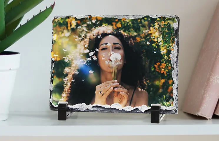 Cadre photo personnalisé sur ardoise, une femme souffle des pissenlits, souvenir unique et élégant.